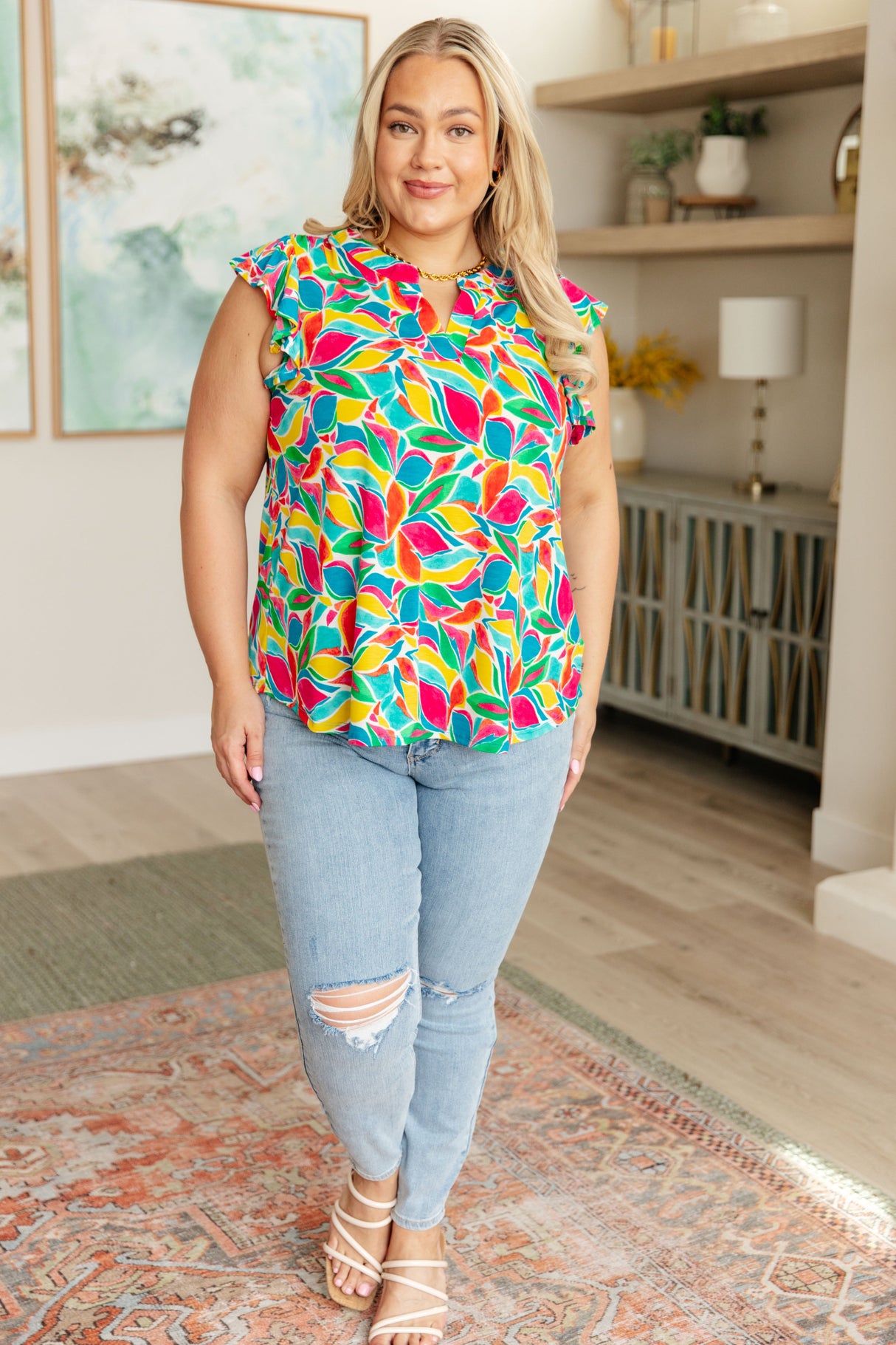 Blusa Lizzy con mangas onduladas en verde azulado y rojo con estampado floral moderno