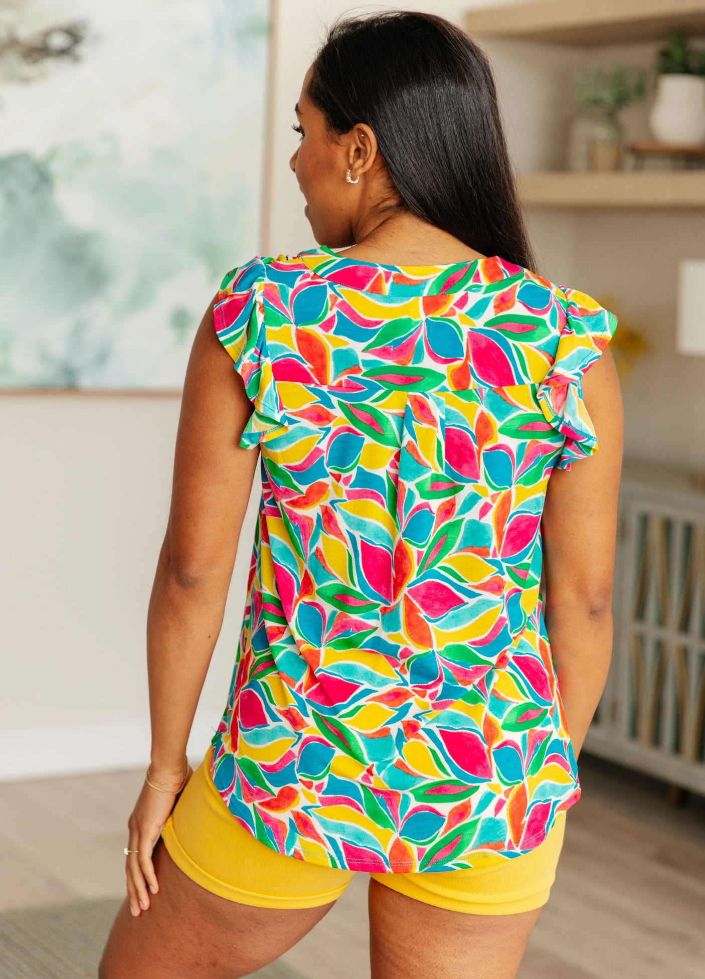 Blusa Lizzy con mangas onduladas en verde azulado y rojo con estampado floral moderno