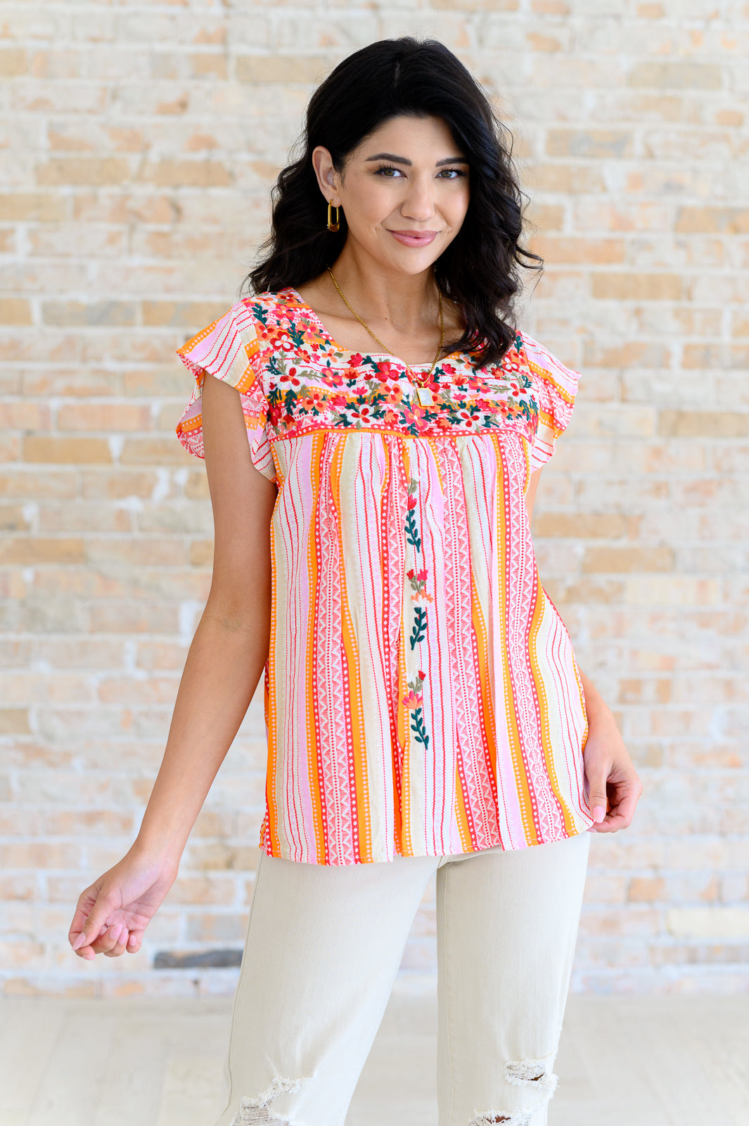 Blusa con mangas onduladas y flores de naranja