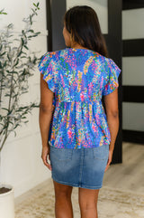 Top azul con mangas onduladas y alerta de coqueteo