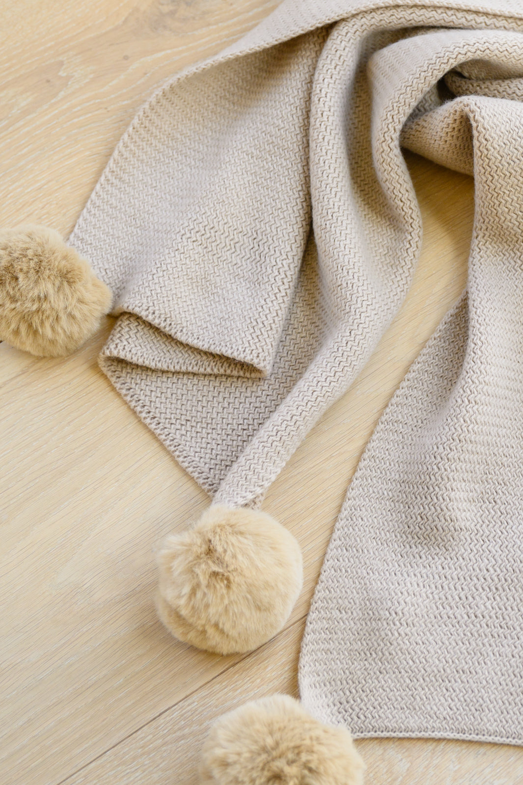 Bufanda de punto con pompones suaves en color beige