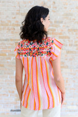 Blusa con mangas onduladas y flores de naranja
