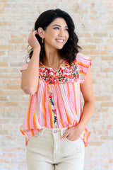 Blusa con mangas onduladas y flores de naranja